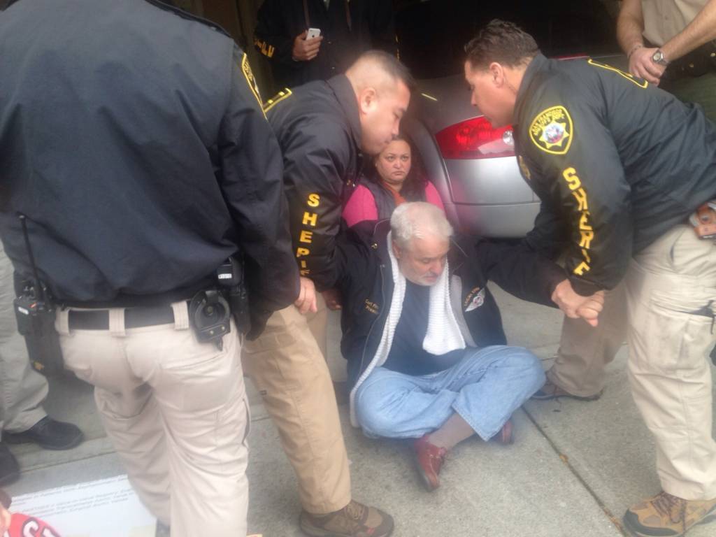 Deputy sheriffs remove protester Carl Finamore from Pastor Dorn's home