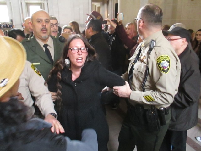 Protester is dragged off by deputy sheriffs -- but other than shouting, what did she do wrong?