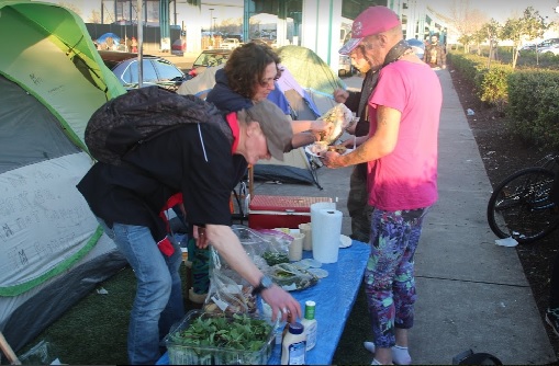 Homeless campers share a meal under the freeway in a community that's very different from what C.W. Nevius portrayed