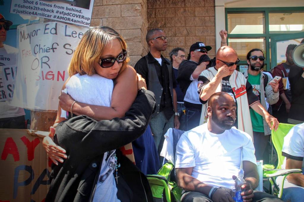 Gwen Woods, mother of Mario Woods, hugs Equipto after her emotional speech to the rally. 