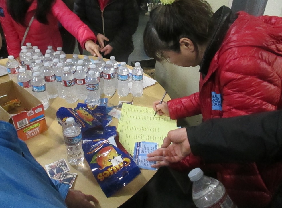 A supporter of the Chiu slate uses a card to fill out multiple ballots